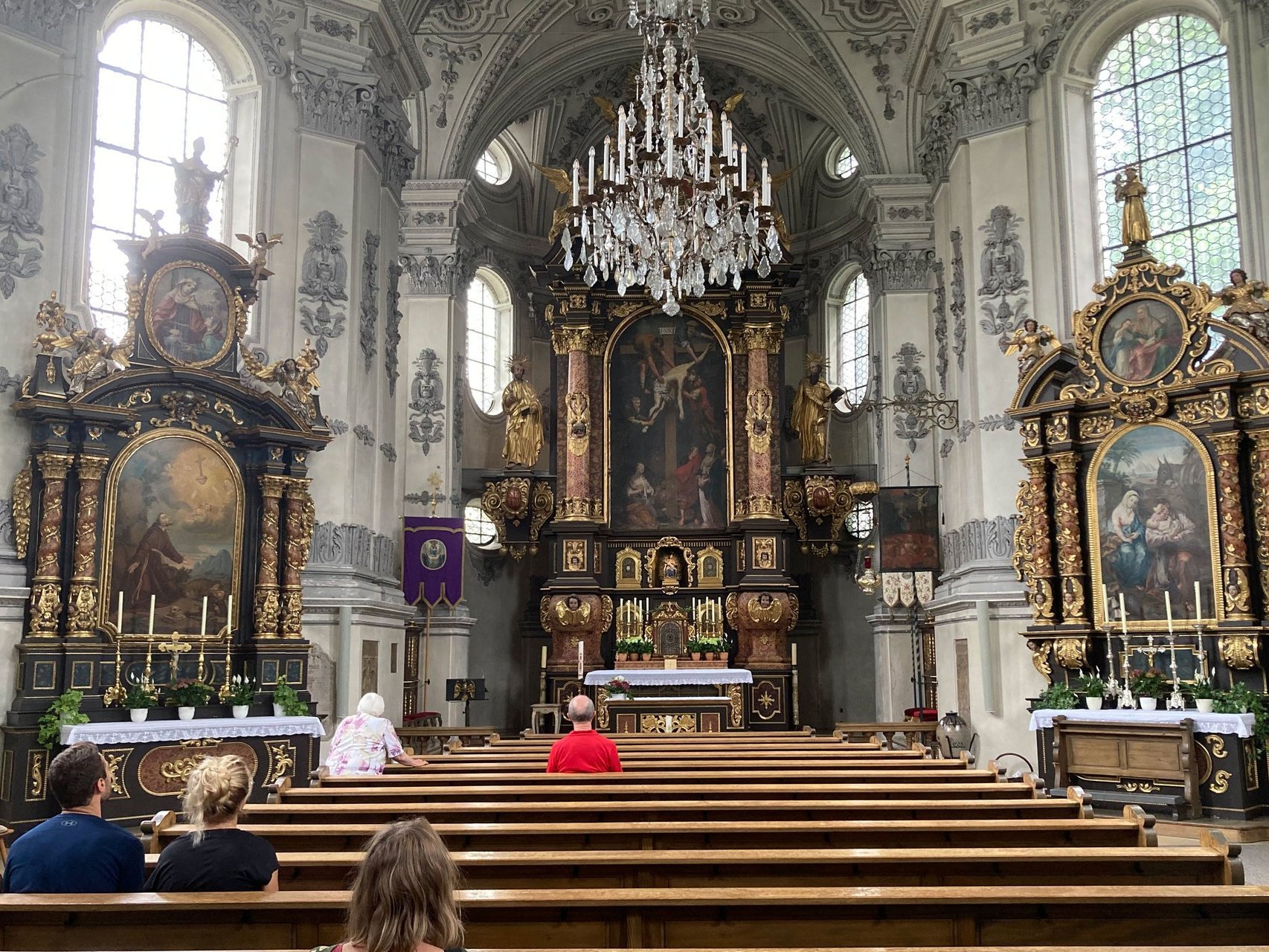 Innenaufnahme der Kirche mit einigen betenden Besuchern