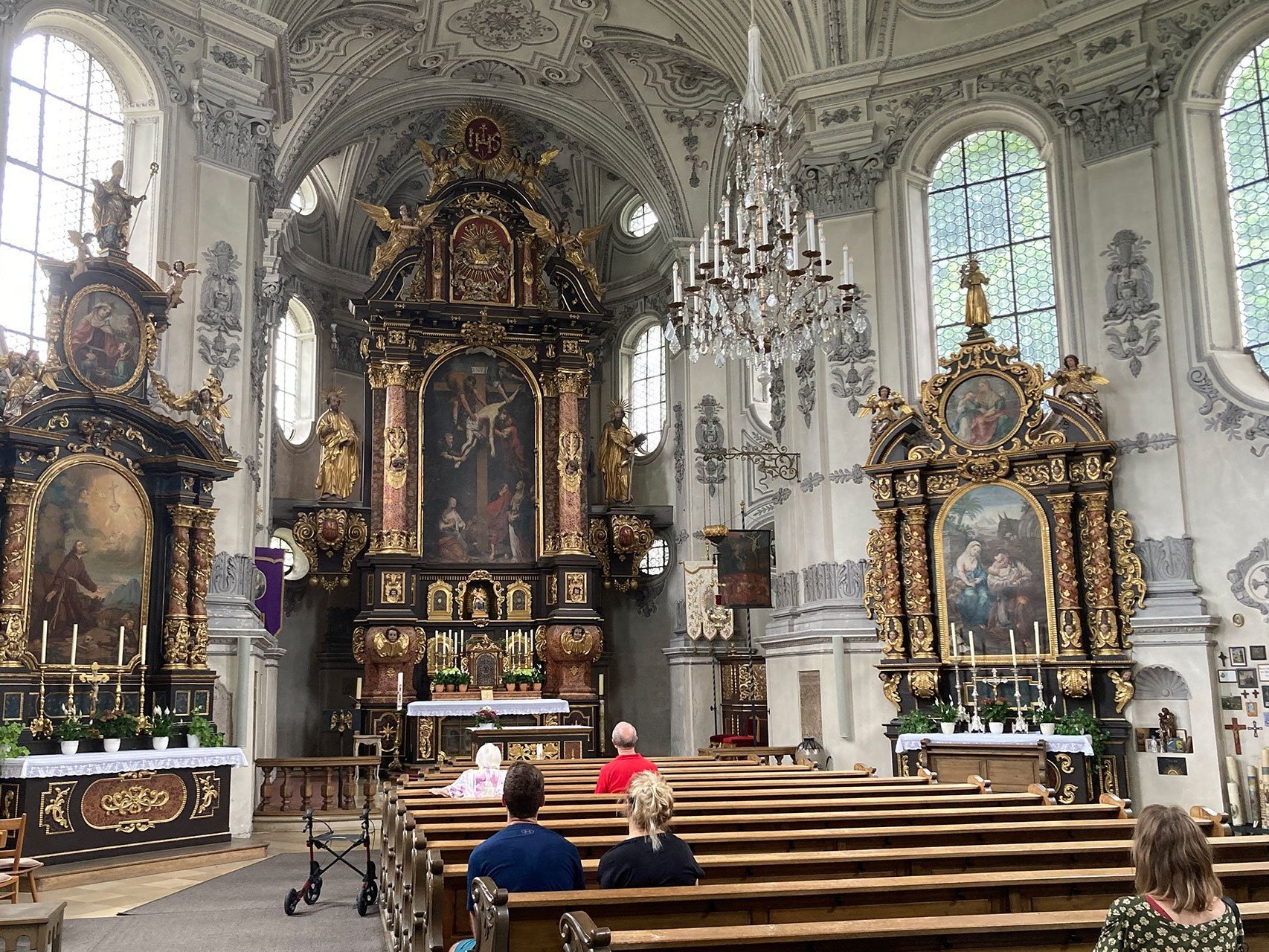 Innenaufnahme der Kirche mit einigen betenden Besuchern