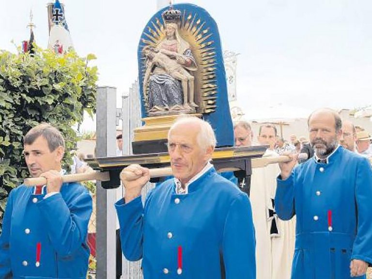 Männer in blauer Uniform tragen ein Muttergottes-Abbild